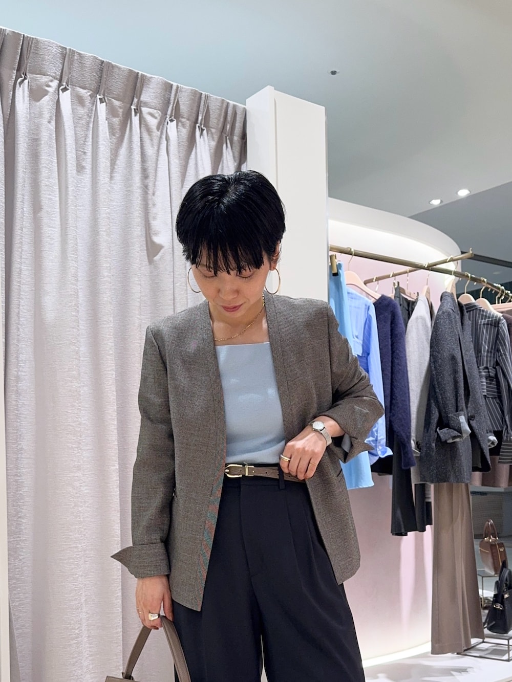 ブルー系のニット/セーター、ベージュ系のノーカラージャケット、ベージュ系のショルダーバッグを着用したレディースの秋コーディネートの2枚目の写真