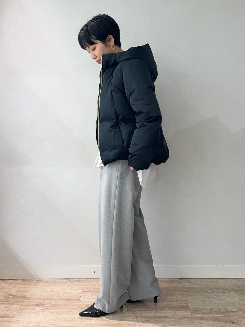 ベージュ系のニット/セーター、ホワイト系のシャツ/ブラウス、ブルー系のダウンジャケット/コートを着用したレディースの冬コーディネートの2枚目の写真