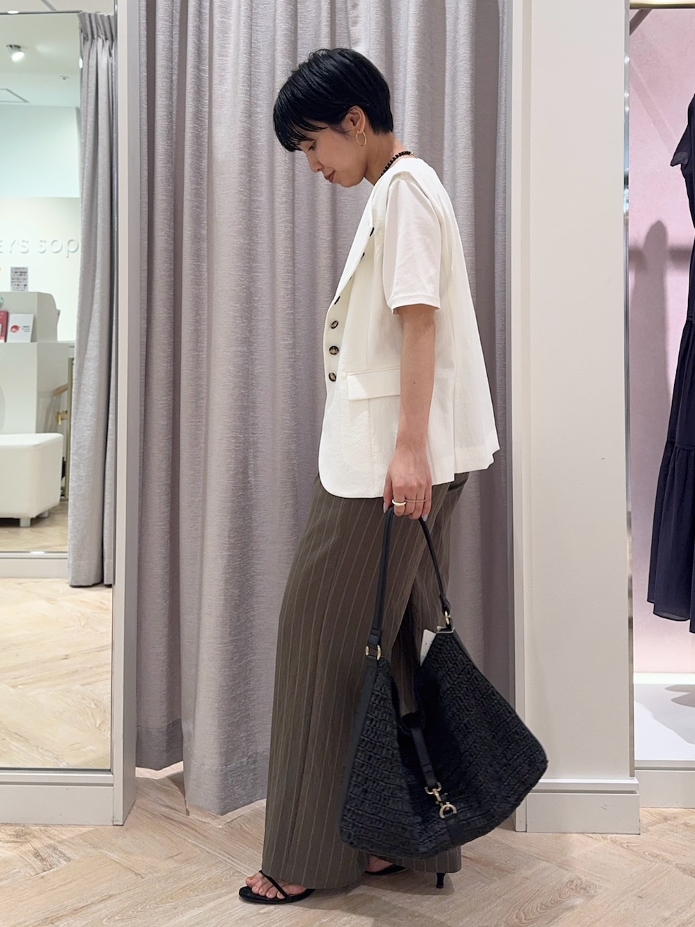 ブラック系のショルダーバッグ、グリーン系のその他パンツ、ホワイト系のTシャツ/カットソーを着用したレディースの夏コーディネートの2枚目の写真