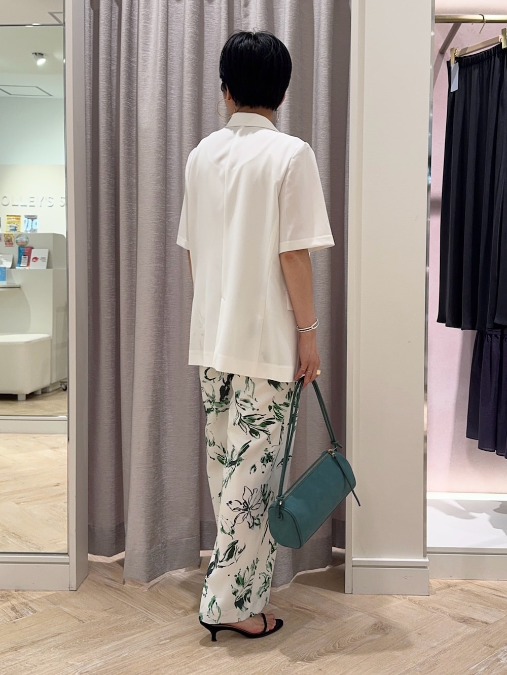グリーン系のショルダーバッグ、ホワイト系のその他パンツ、ホワイト系のテーラードジャケットを着用したレディースの夏コーディネートの3枚目の写真