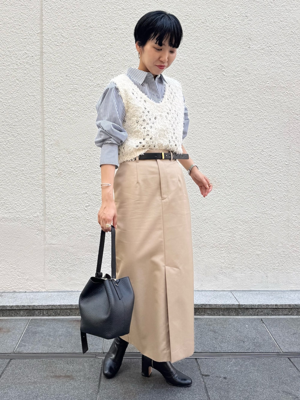 ブルー系のシャツ/ブラウス、ホワイト系のベスト、ベージュ系のスカートを着用したレディースの秋コーディネートの3枚目の写真