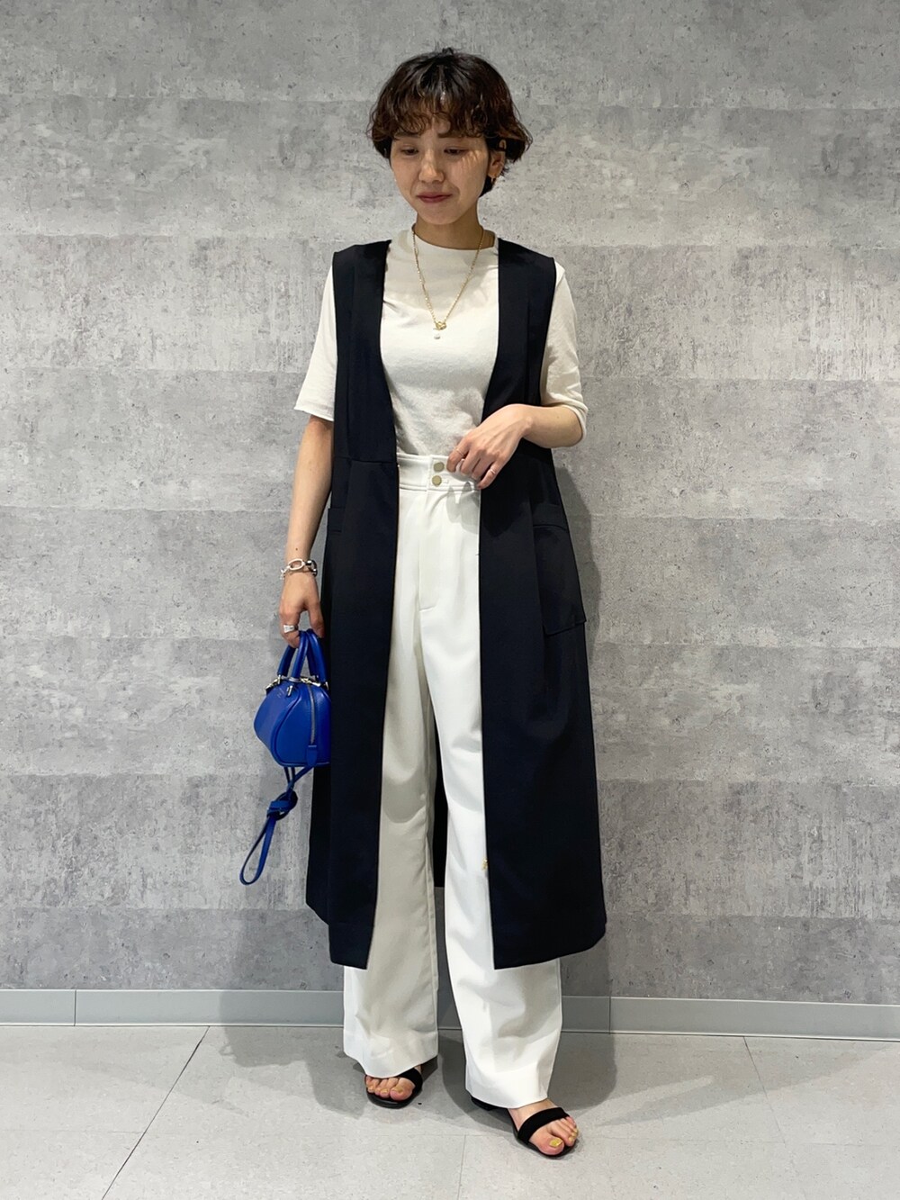 ブラック系のワンピース、ホワイト系のその他パンツ、ブルー系のボストンバッグを着用したレディースの春コーディネートの3枚目の写真