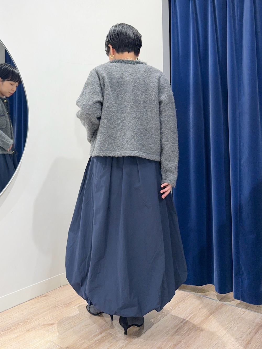 グレー系のニット/セーター、グレー系のワンピースを着用したレディースの冬コーディネートの2枚目の写真