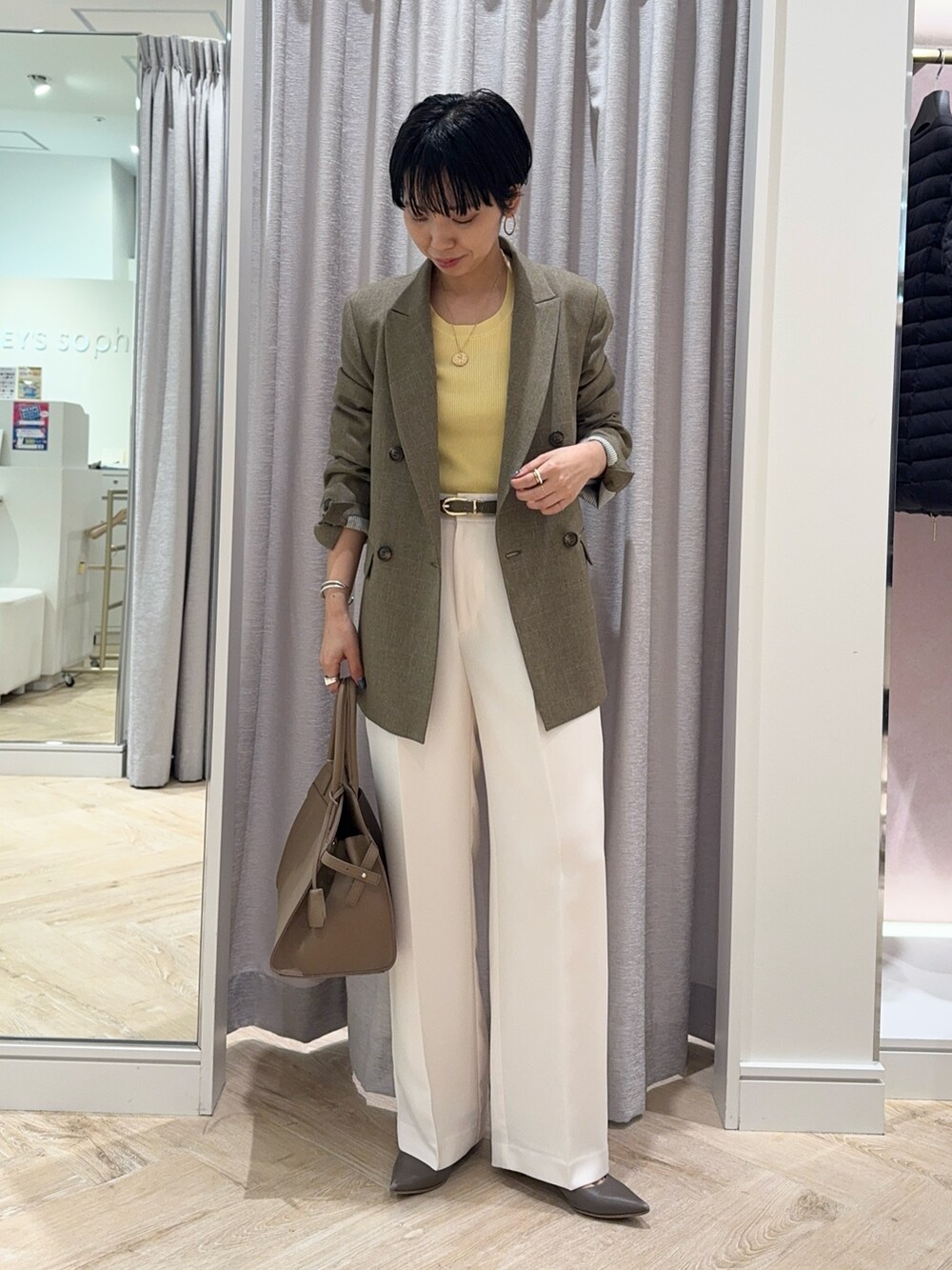 ホワイト系のその他パンツ、ベージュ系のショルダーバッグ、イエロー系のニット/セーターを着用したレディースの秋コーディネートの5枚目の写真