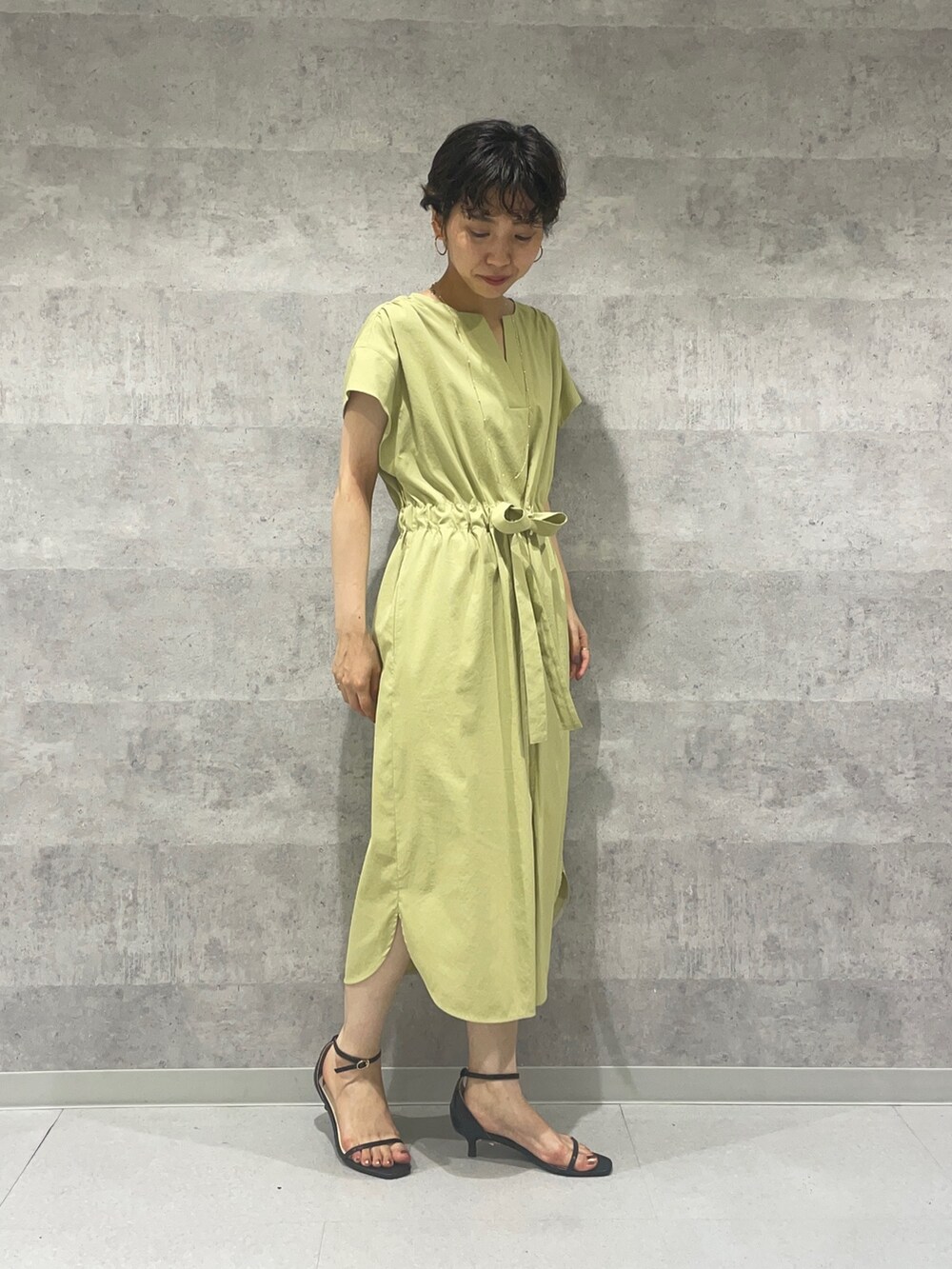 ブラック系のカーディガン/ボレロ、ブラック系のサンダル、イエロー系のワンピースを着用したレディースの夏コーディネートの4枚目の写真