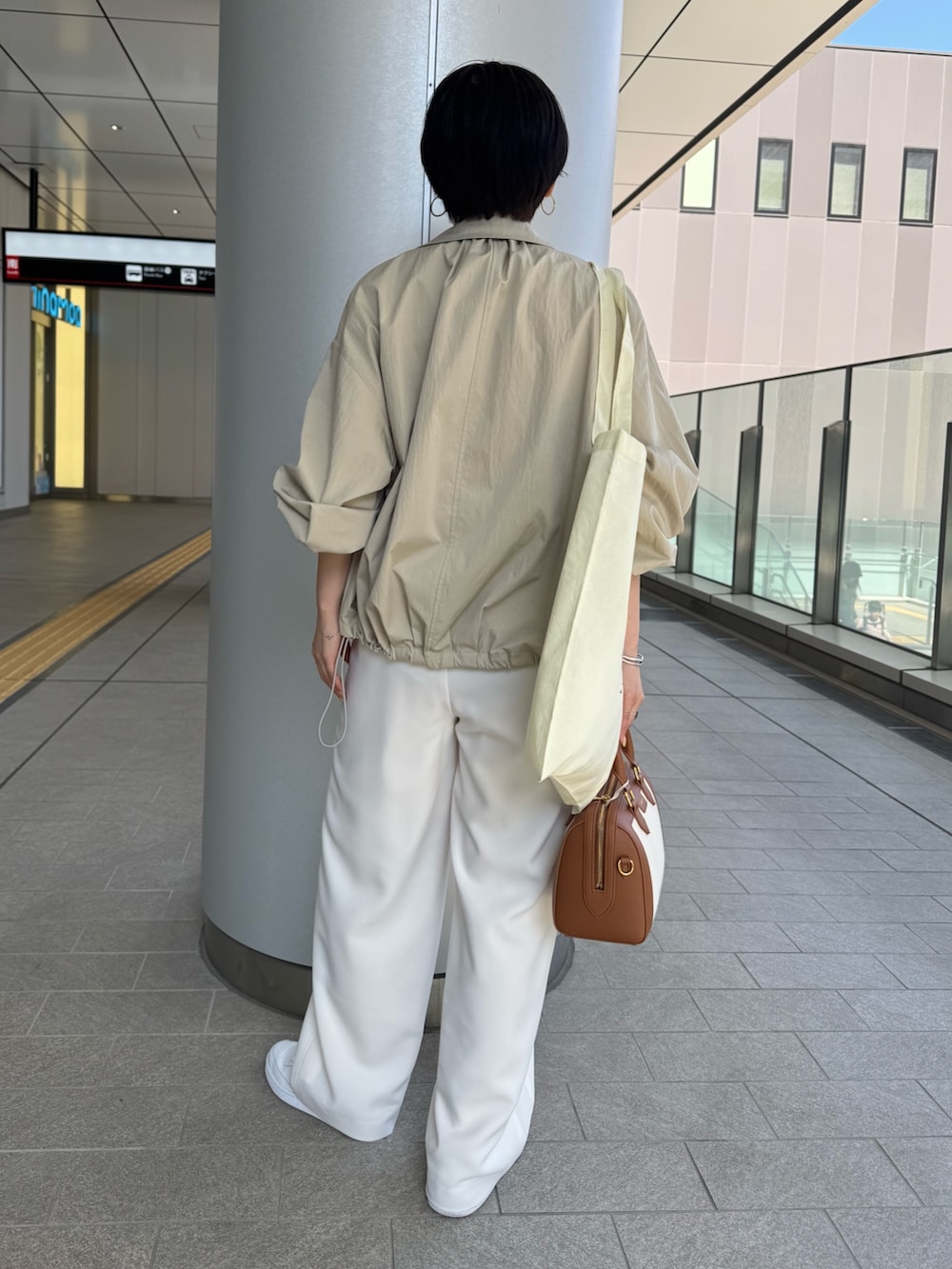 ベージュ系のニット/セーター、ベージュ系のブルゾン、ブラウン系のボストンバッグを着用したレディースの春コーディネートの6枚目の写真