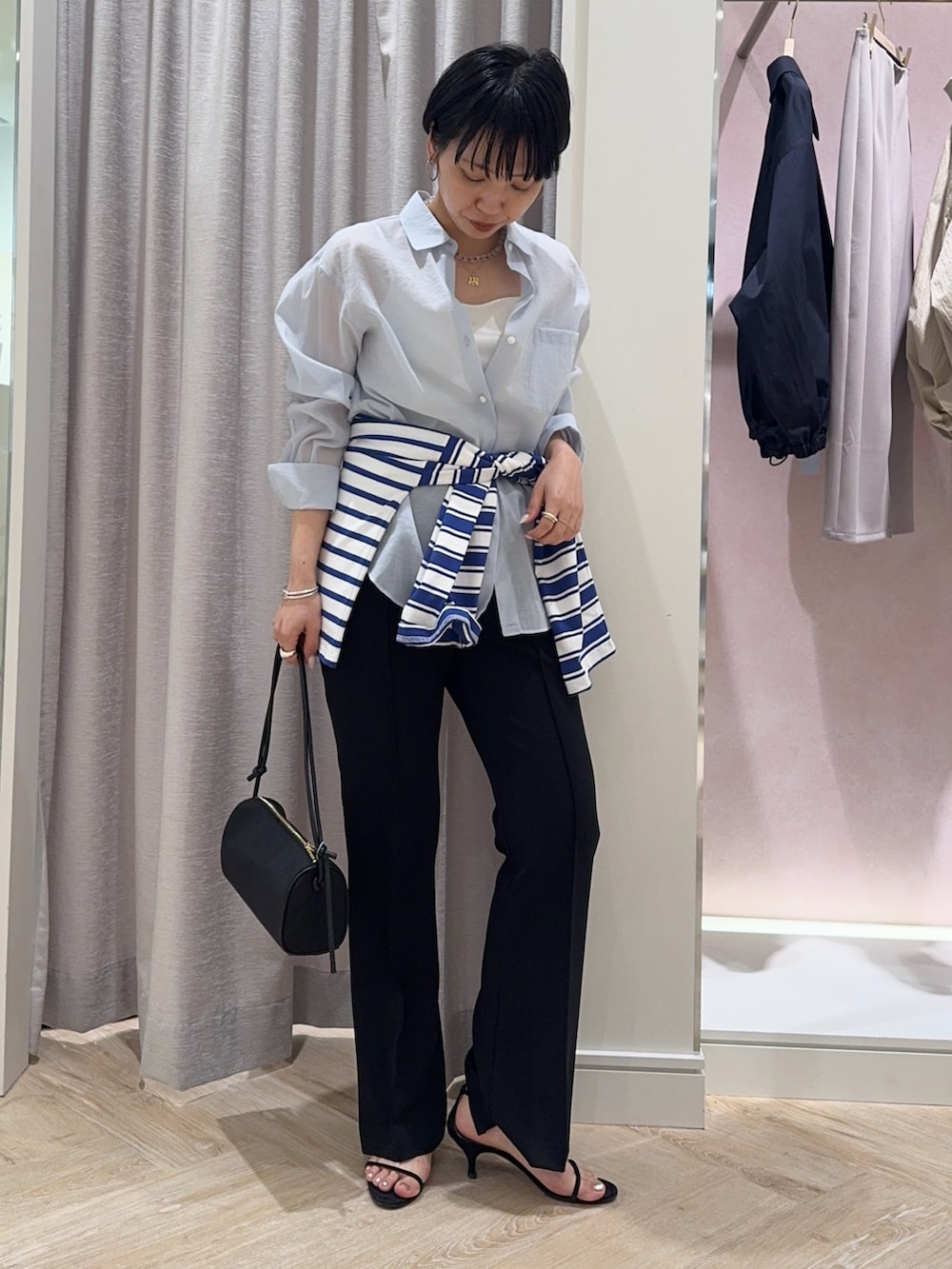 ブルー系のシャツ/ブラウス、ホワイト系のキャミソール、ブラック系のショルダーバッグを着用したレディースの春コーディネートの4枚目の写真