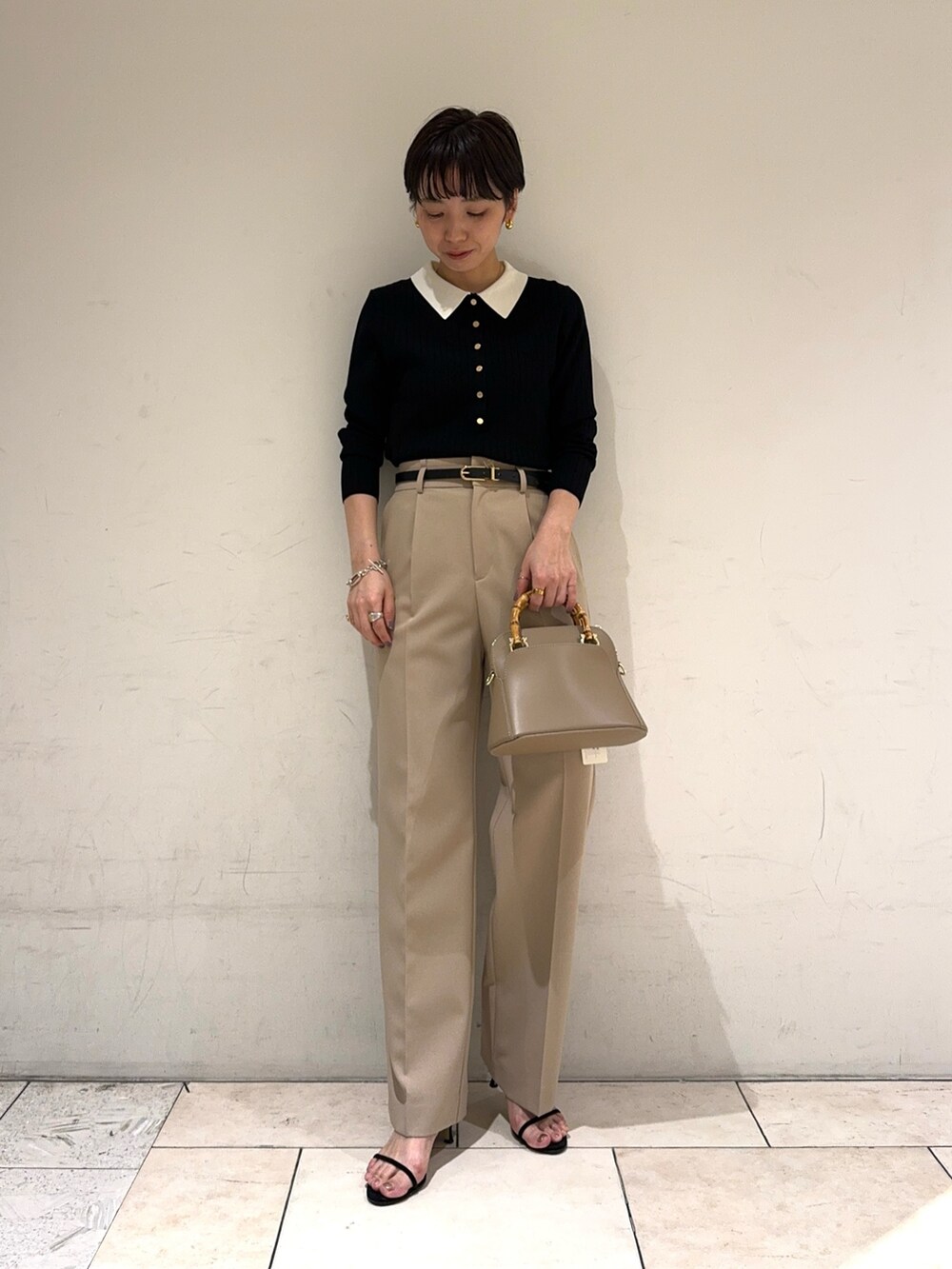 ブラック系のニット/セーター、ベージュ系のその他パンツ、ベージュ系のショルダーバッグを着用したレディースの冬コーディネートの2枚目の写真