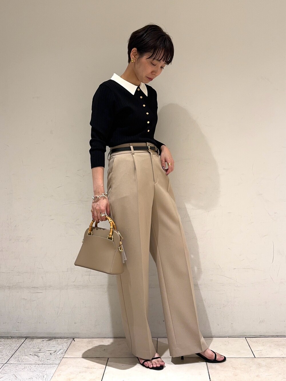 ブラック系のニット/セーター、ベージュ系のその他パンツ、ベージュ系のショルダーバッグを着用したレディースの冬コーディネートの3枚目の写真