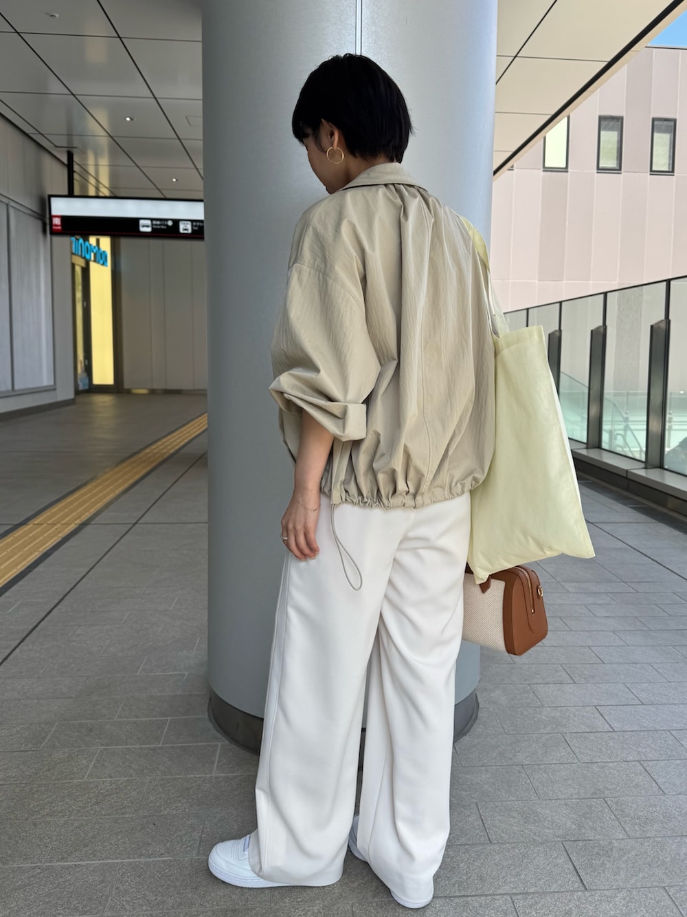 ベージュ系のニット/セーター、ベージュ系のブルゾン、ブラウン系のボストンバッグを着用したレディースの春コーディネートの8枚目の写真