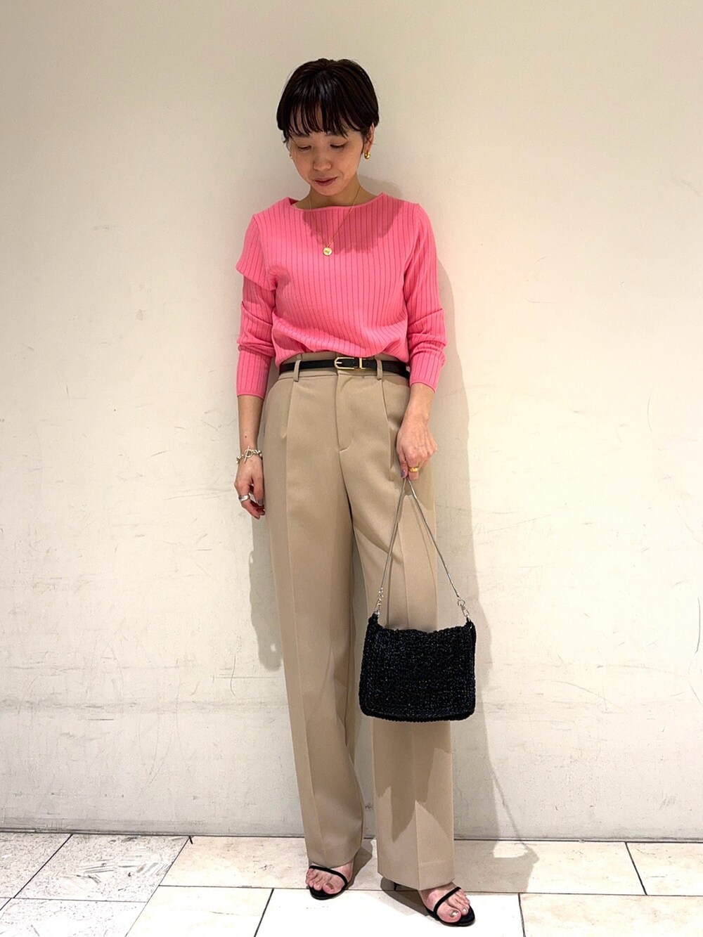 ピンク系のニット/セーター、ベージュ系のその他パンツ、ブラック系のショルダーバッグを着用したレディースの冬コーディネートの5枚目の写真