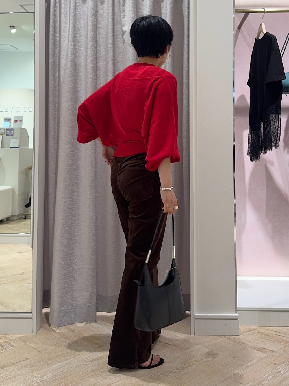 レッド系のニット/セーター、ブラウン系のその他パンツ、ブラック系のショルダーバッグを着用したレディースの夏コーディネートの4枚目の写真