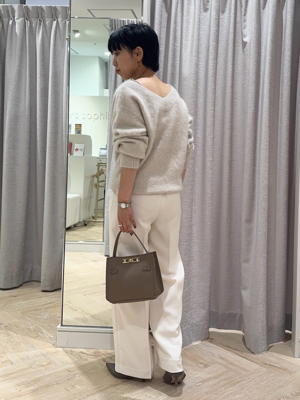 ベージュ系のニット/セーター、ベージュ系のショルダーバッグ、ホワイト系のその他パンツを着用したレディースの秋コーディネートの3枚目の写真
