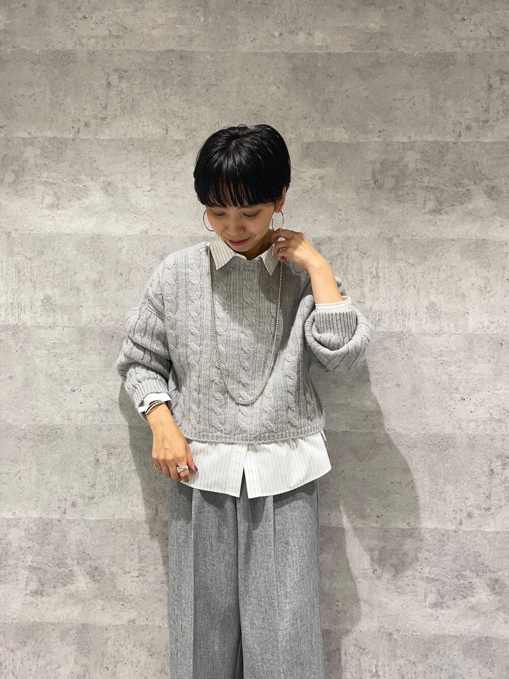グレー系のその他パンツ、ホワイト系のシャツ/ブラウス、グレー系のニット/セーターを着用したレディースの秋コーディネートの5枚目の写真