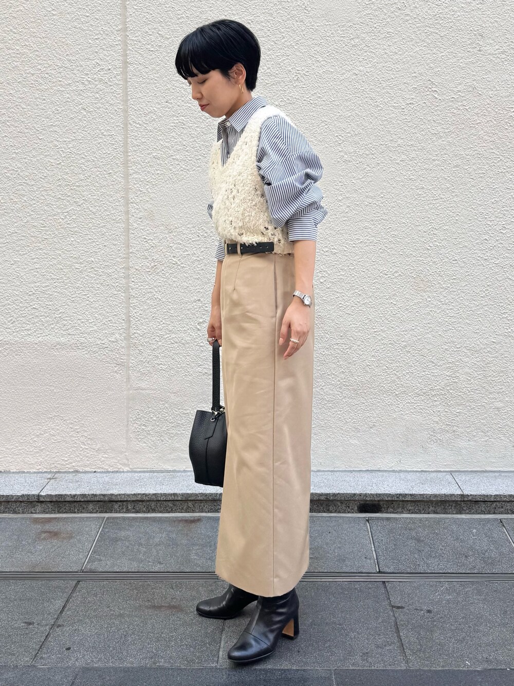 ブルー系のシャツ/ブラウス、ホワイト系のベスト、ベージュ系のスカートを着用したレディースの秋コーディネートの6枚目の写真