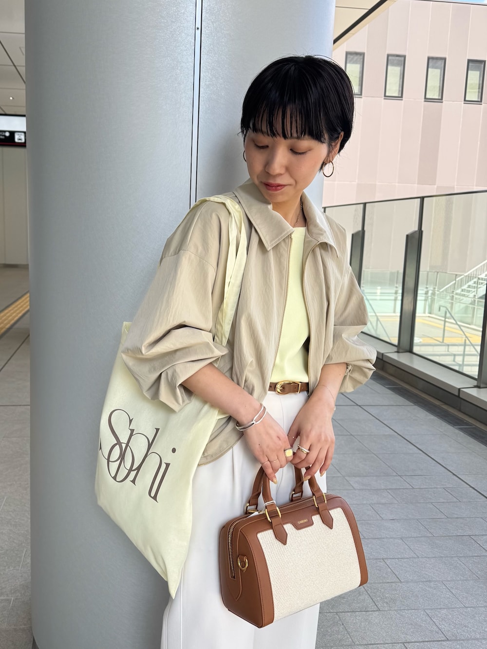 ベージュ系のニット/セーター、ベージュ系のブルゾン、ブラウン系のボストンバッグを着用したレディースの春コーディネートの9枚目の写真