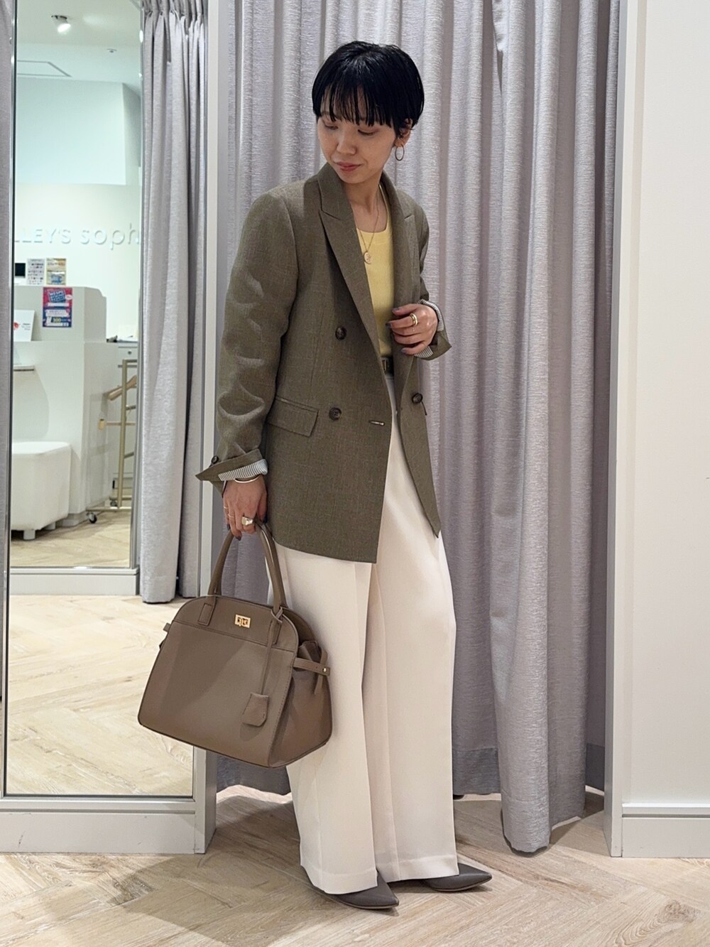 ホワイト系のその他パンツ、ベージュ系のショルダーバッグ、イエロー系のニット/セーターを着用したレディースの秋コーディネートの3枚目の写真