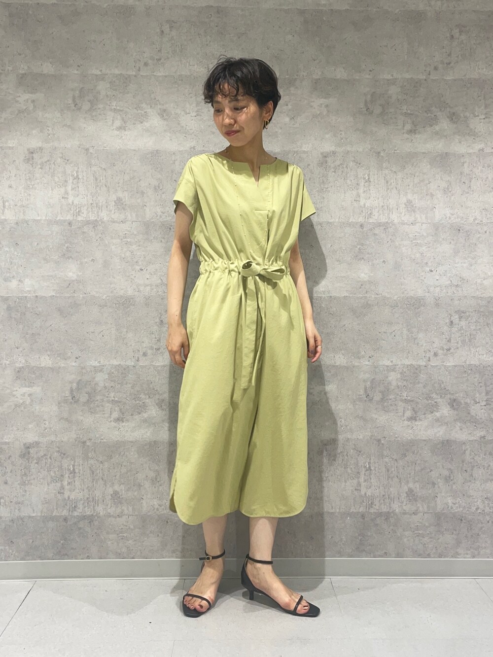 ブラック系のカーディガン/ボレロ、ブラック系のサンダル、イエロー系のワンピースを着用したレディースの夏コーディネートの3枚目の写真