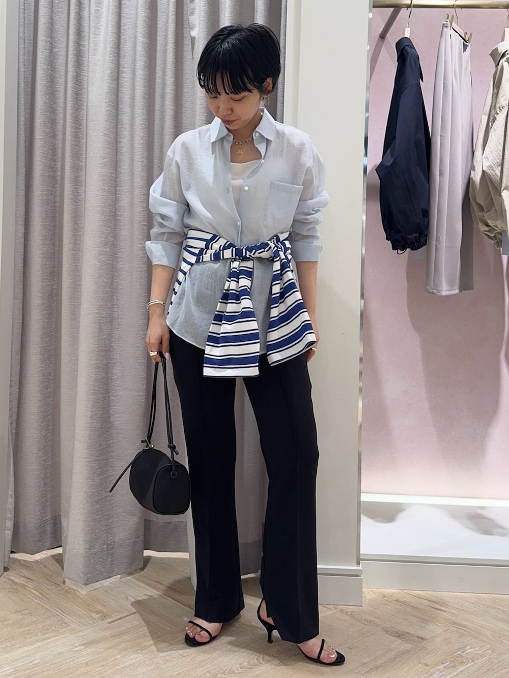 ブルー系のシャツ/ブラウス、ホワイト系のキャミソール、ブラック系のショルダーバッグを着用したレディースの春コーディネートの3枚目の写真