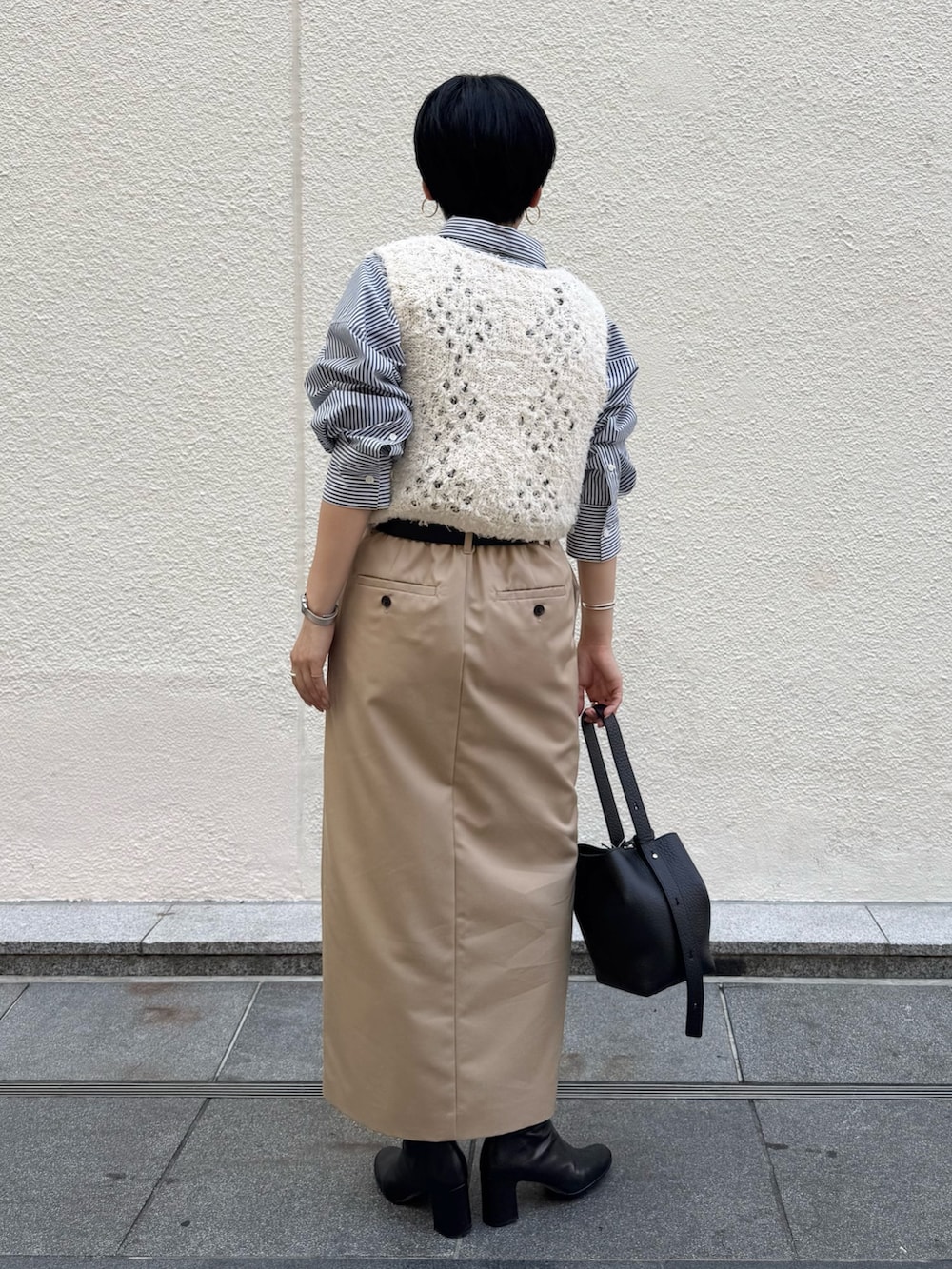 ブルー系のシャツ/ブラウス、ホワイト系のベスト、ベージュ系のスカートを着用したレディースの秋コーディネートの5枚目の写真