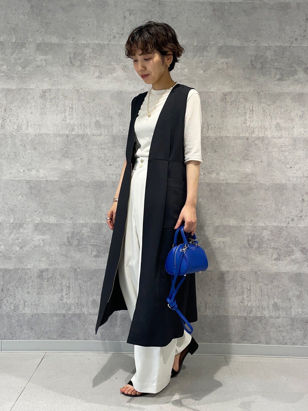 ブラック系のワンピース、ホワイト系のその他パンツ、ブルー系のボストンバッグを着用したレディースの春コーディネートの4枚目の写真