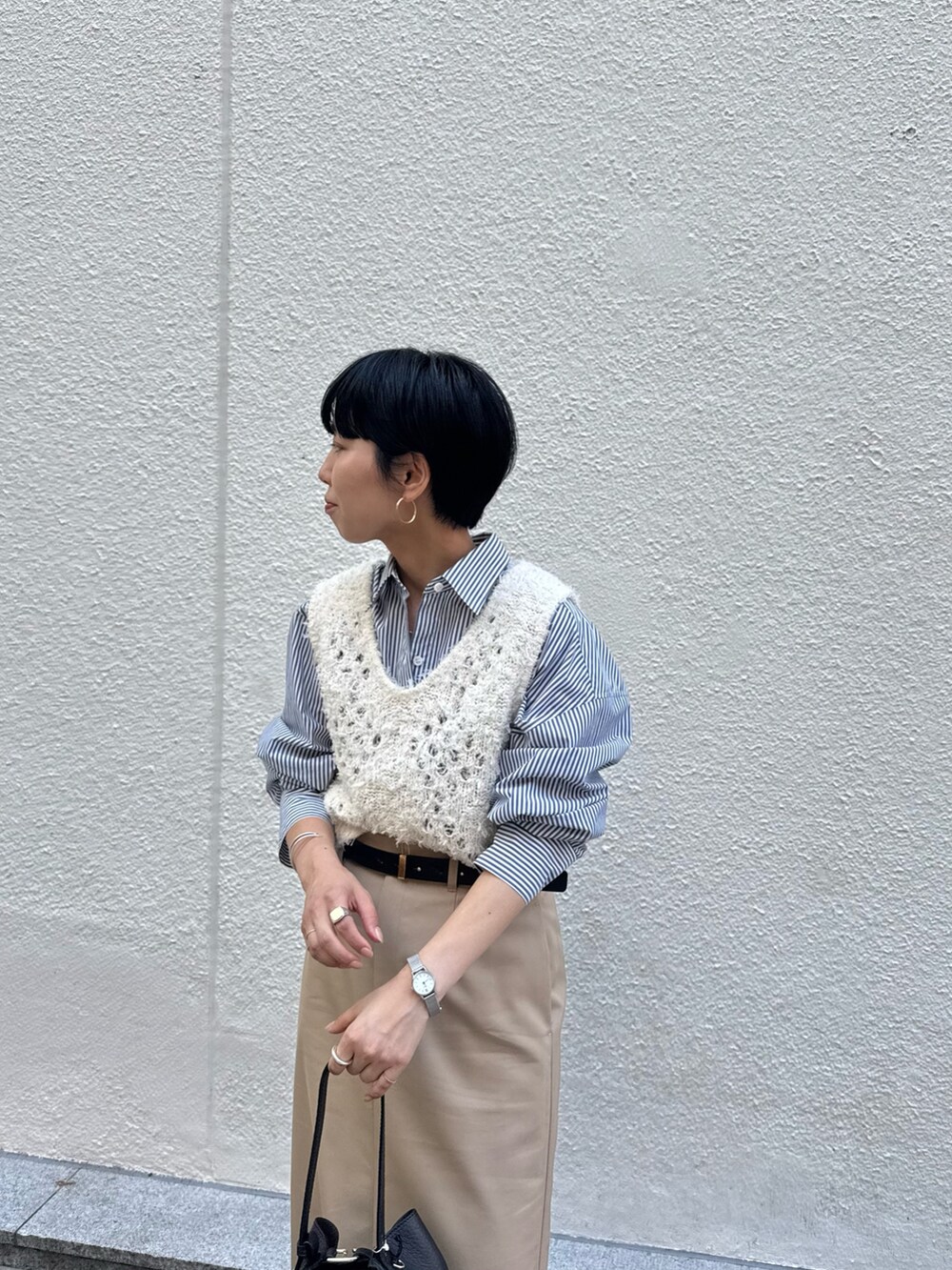 ブルー系のシャツ/ブラウス、ホワイト系のベスト、ベージュ系のスカートを着用したレディースの秋コーディネートの8枚目の写真