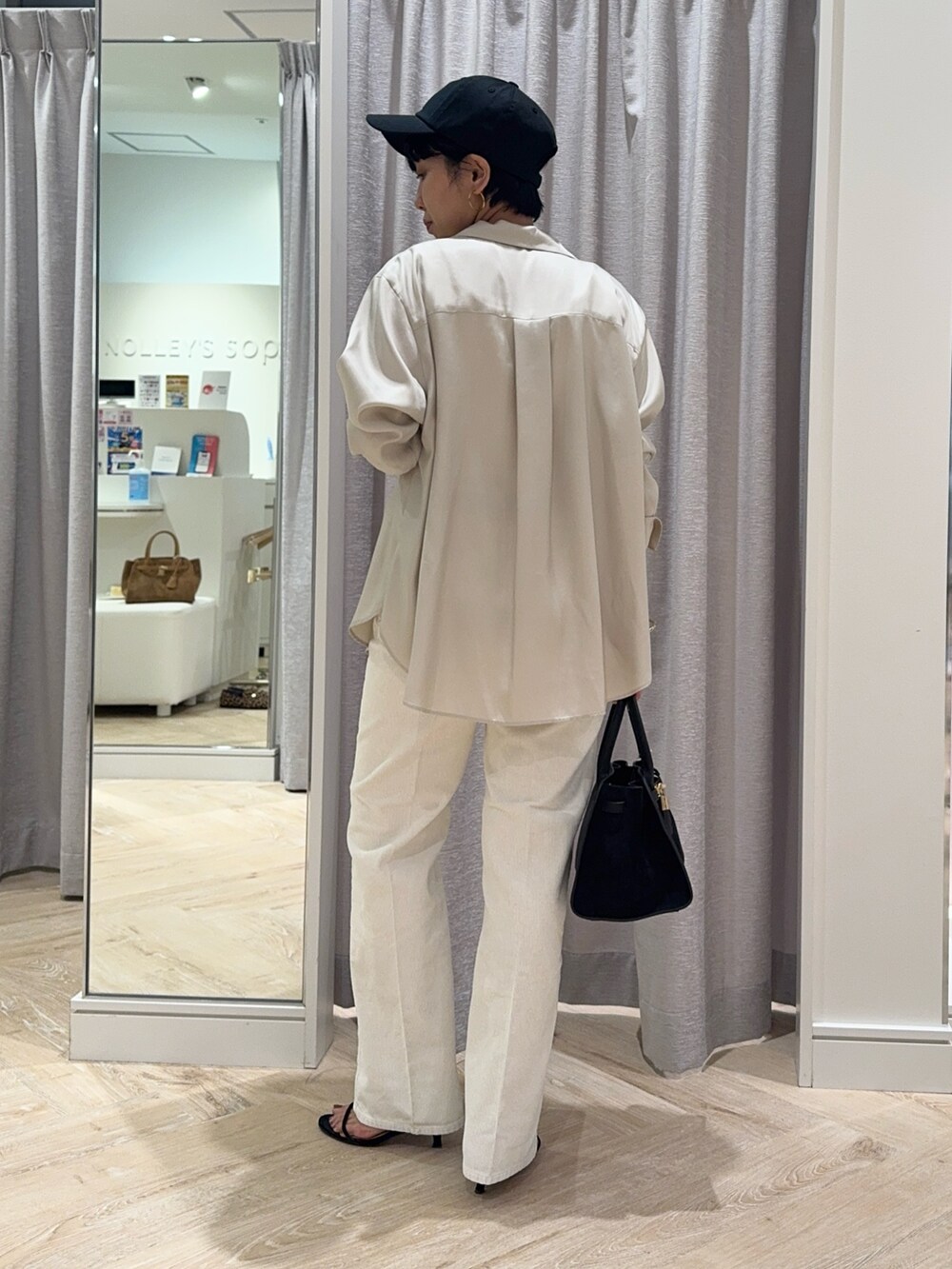 ブラック系のトートバッグ、ホワイト系のデニムパンツ、ホワイト系のタンクトップを着用したレディースの秋コーディネートの4枚目の写真