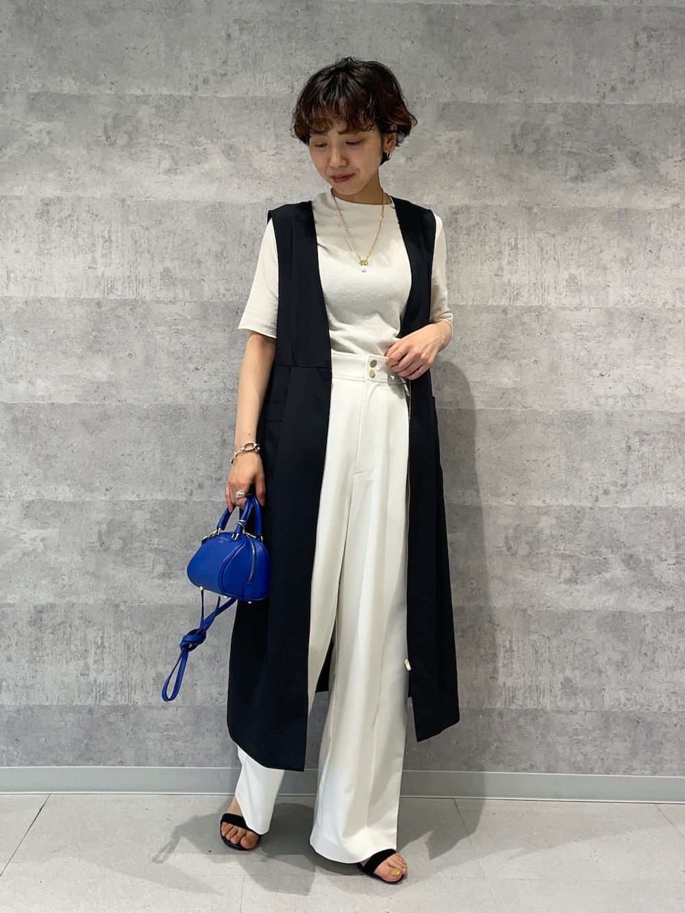 ブラック系のワンピース、ホワイト系のその他パンツ、ブルー系のボストンバッグを着用したレディースの春コーディネートの2枚目の写真