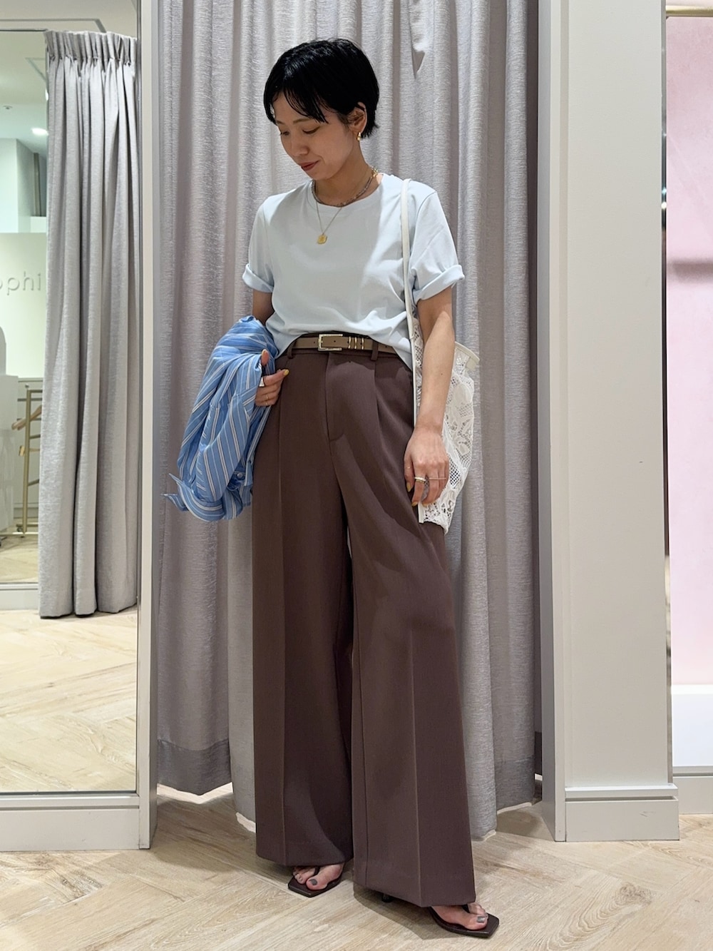 ブラウン系のその他パンツ、ブルー系のTシャツ/カットソー、ホワイト系のショルダーバッグを着用したレディースの春コーディネートの5枚目の写真