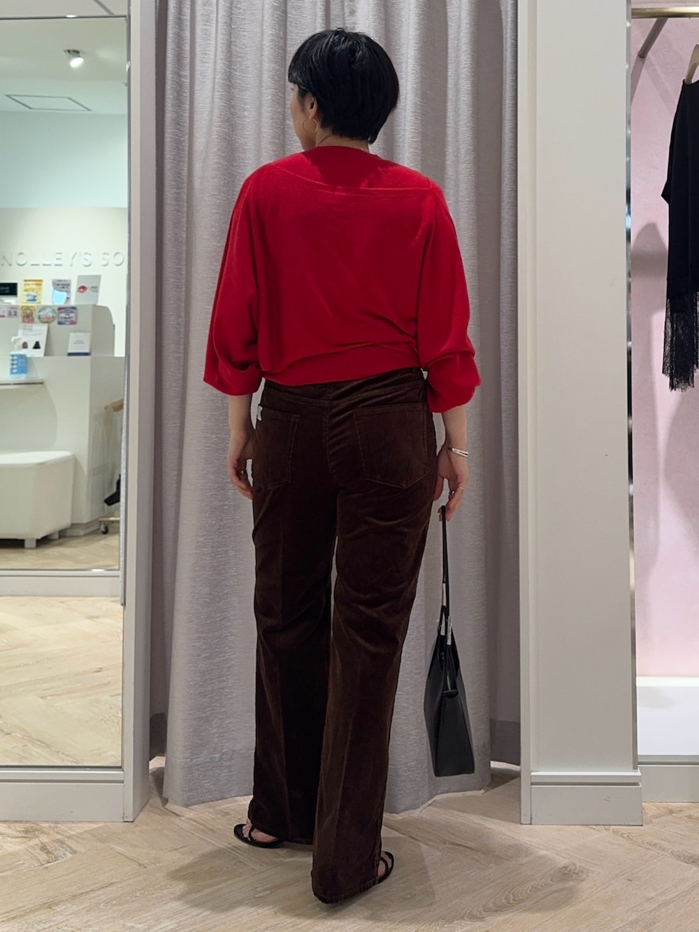 レッド系のニット/セーター、ブラウン系のその他パンツ、ブラック系のショルダーバッグを着用したレディースの夏コーディネートの2枚目の写真