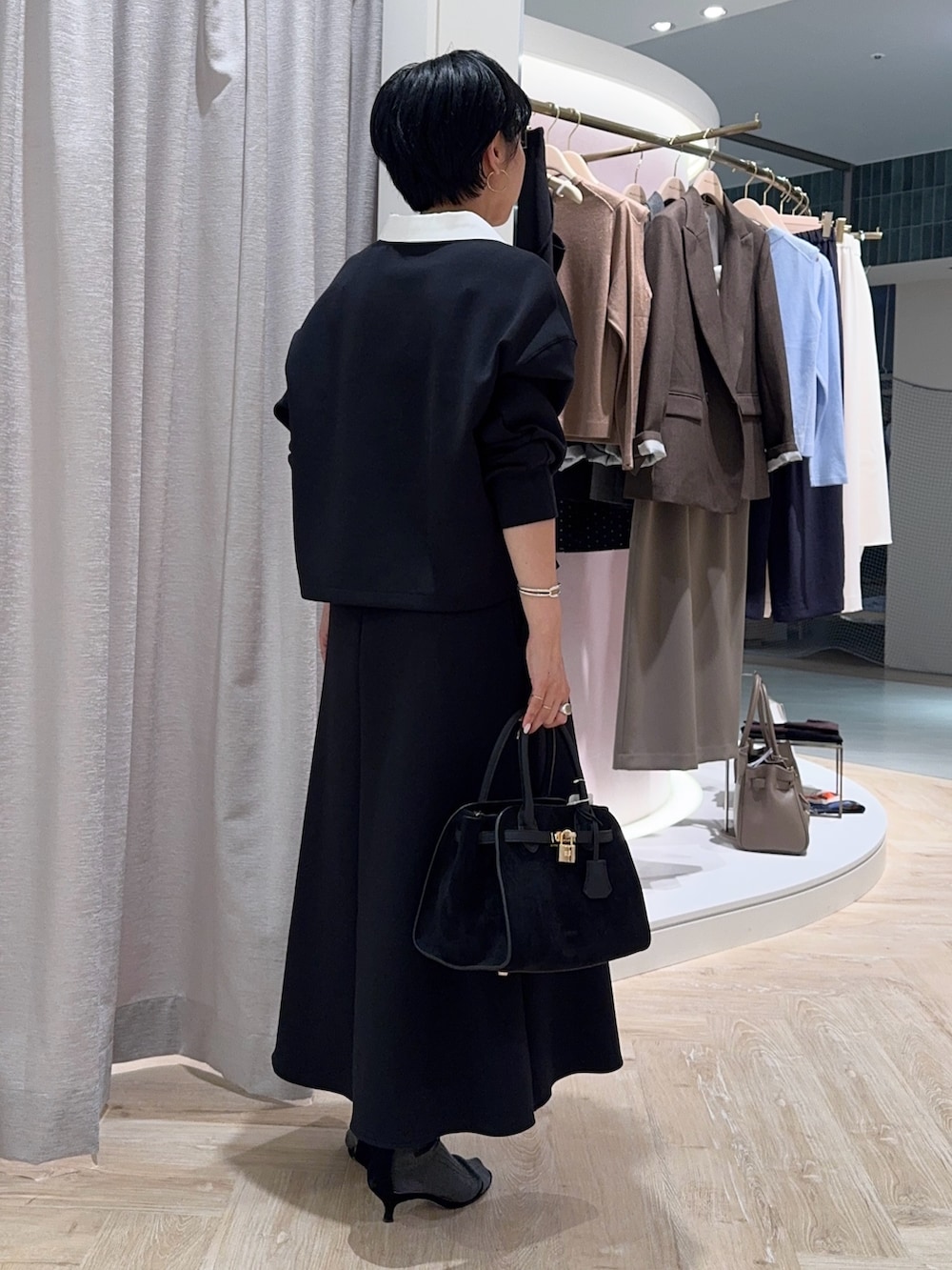 ブラック系のTシャツ/カットソー、ブラック系のトートバッグ、ブラック系のスカートを着用したレディースの秋コーディネートの2枚目の写真