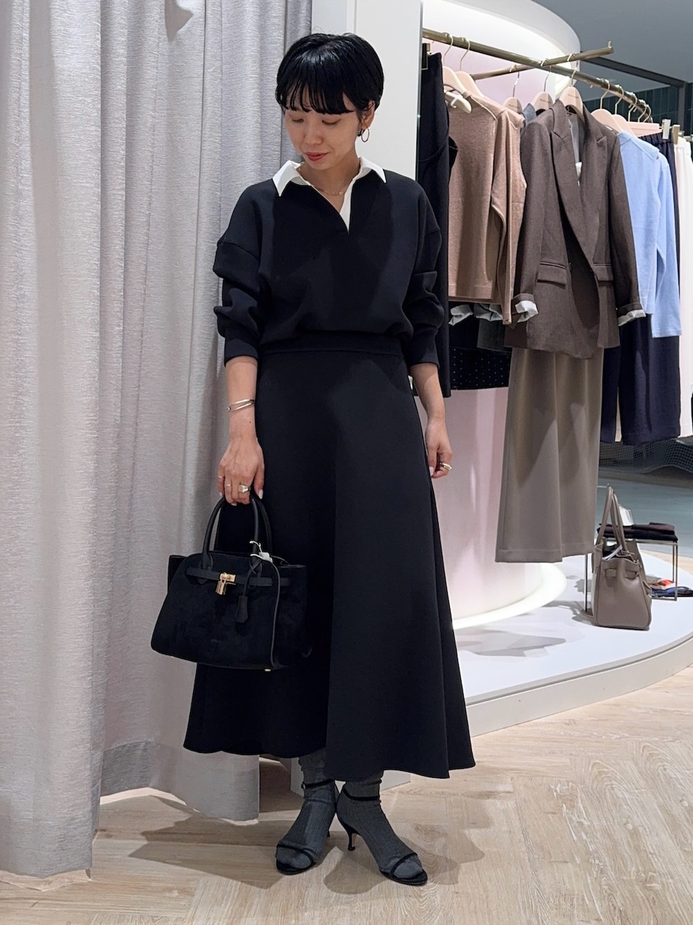 ブラック系のTシャツ/カットソー、ブラック系のトートバッグ、ブラック系のスカートを着用したレディースの秋コーディネートの3枚目の写真