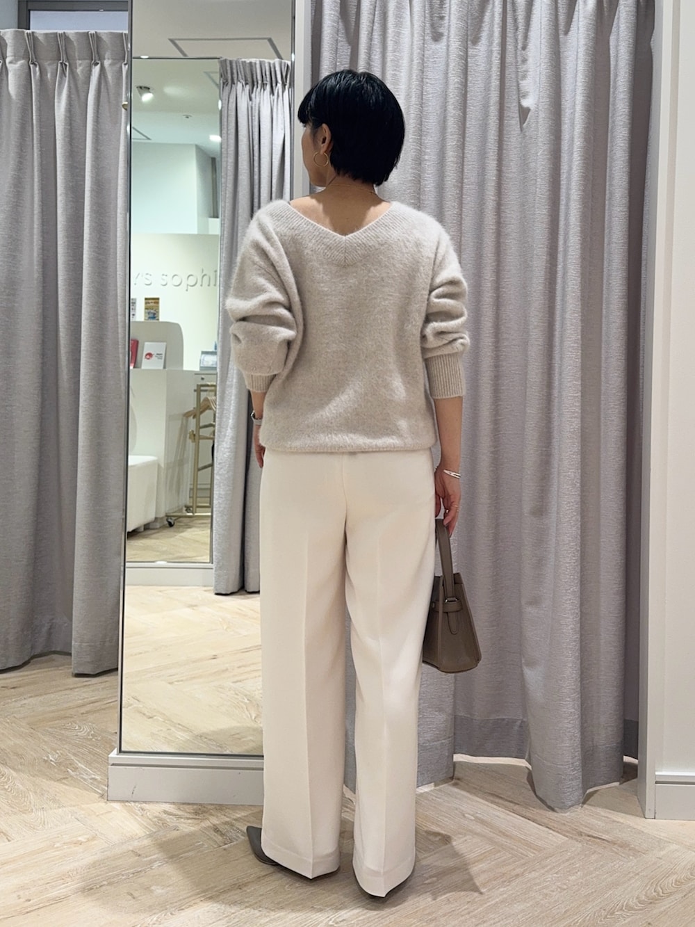 ベージュ系のニット/セーター、ベージュ系のショルダーバッグ、ホワイト系のその他パンツを着用したレディースの秋コーディネートの4枚目の写真