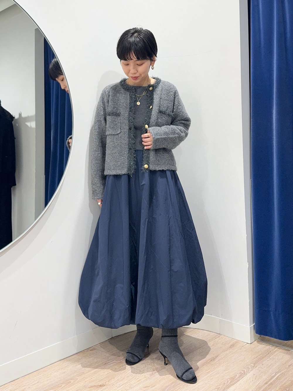 グレー系のニット/セーター、グレー系のワンピースを着用したレディースの冬コーディネートの3枚目の写真