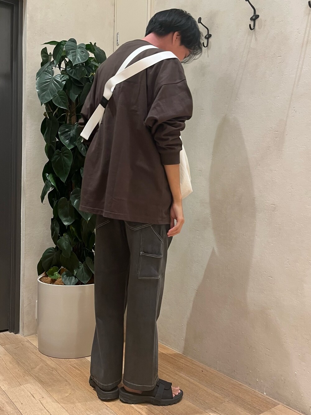 グレー系のTシャツ/カットソー、ホワイト系のショルダーバッグ、グレー系のデニムパンツを着用したメンズの秋コーディネートの3枚目の写真