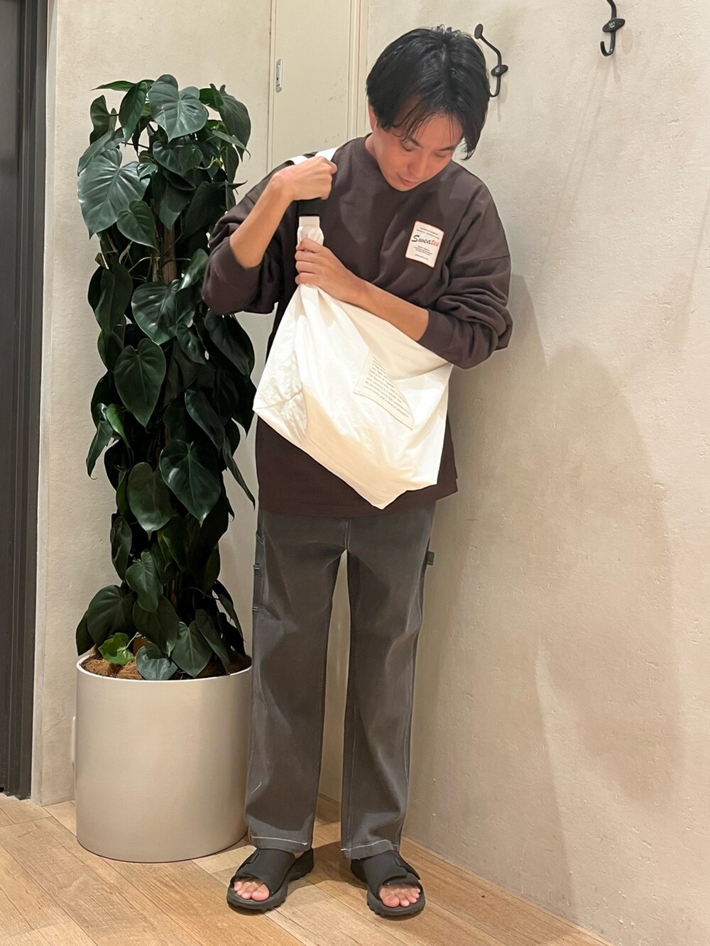 グレー系のTシャツ/カットソー、ホワイト系のショルダーバッグ、グレー系のデニムパンツを着用したメンズの秋コーディネートの2枚目の写真