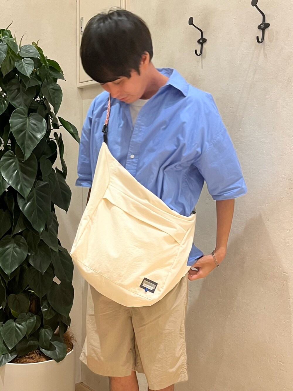 ホワイト系のショルダーバッグ、ブルー系のシャツ/ブラウス、ホワイト系のTシャツ/カットソーを着用したメンズの夏コーディネートの2枚目の写真