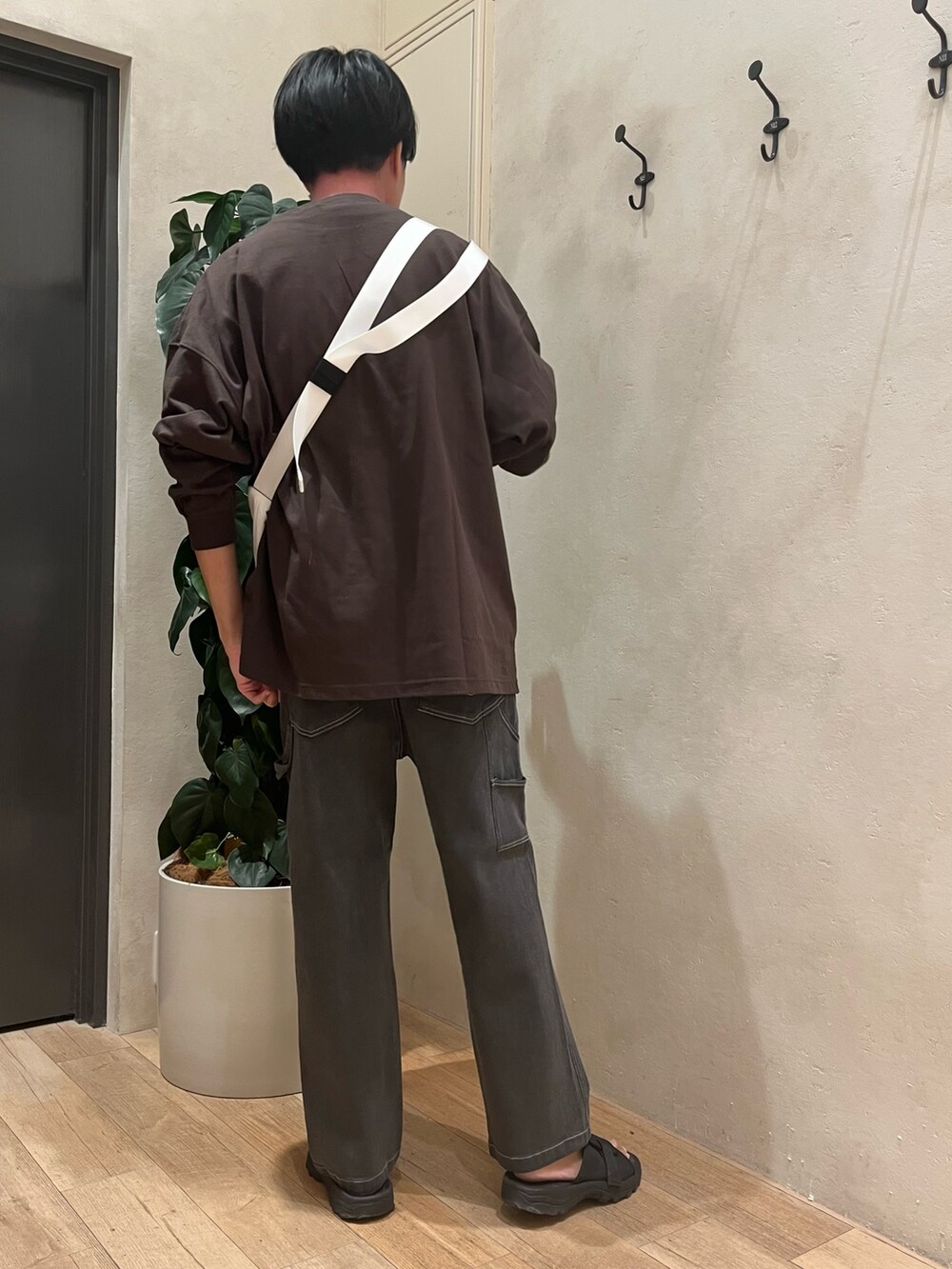 グレー系のTシャツ/カットソー、ホワイト系のショルダーバッグ、グレー系のデニムパンツを着用したメンズの秋コーディネートの4枚目の写真