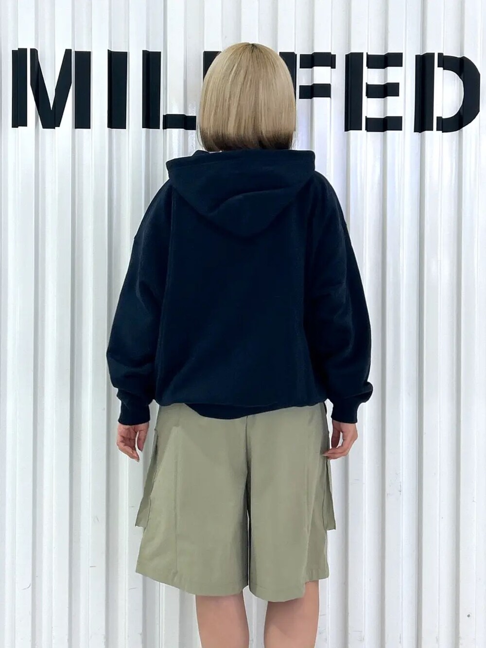 ブルー系のパーカー、ブルー系のバックパック/リュック、グリーン系のラッシュガードを着用したレディースの夏コーディネートの7枚目の写真