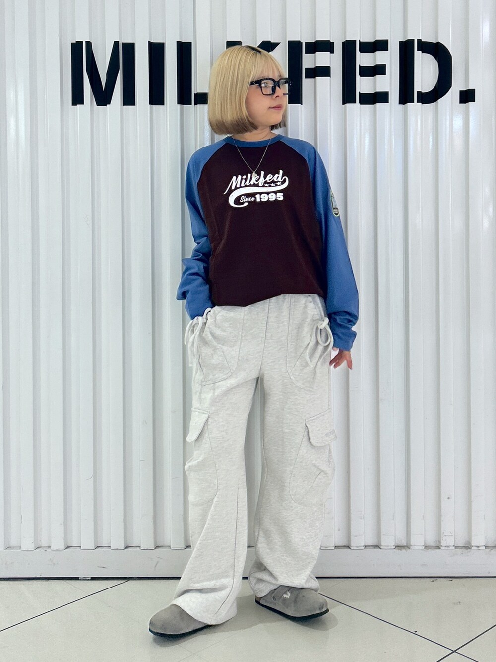 ベージュ系のスウェットパンツ、ブラウン系のTシャツ/カットソー、ブラック系のバックパック/リュックを着用したレディースの夏コーディネートの5枚目の写真