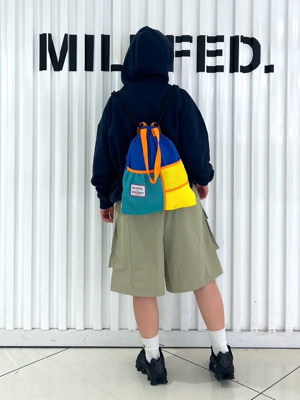 ブルー系のパーカー、ブルー系のバックパック/リュック、グリーン系のラッシュガードを着用したレディースの夏コーディネートの3枚目の写真