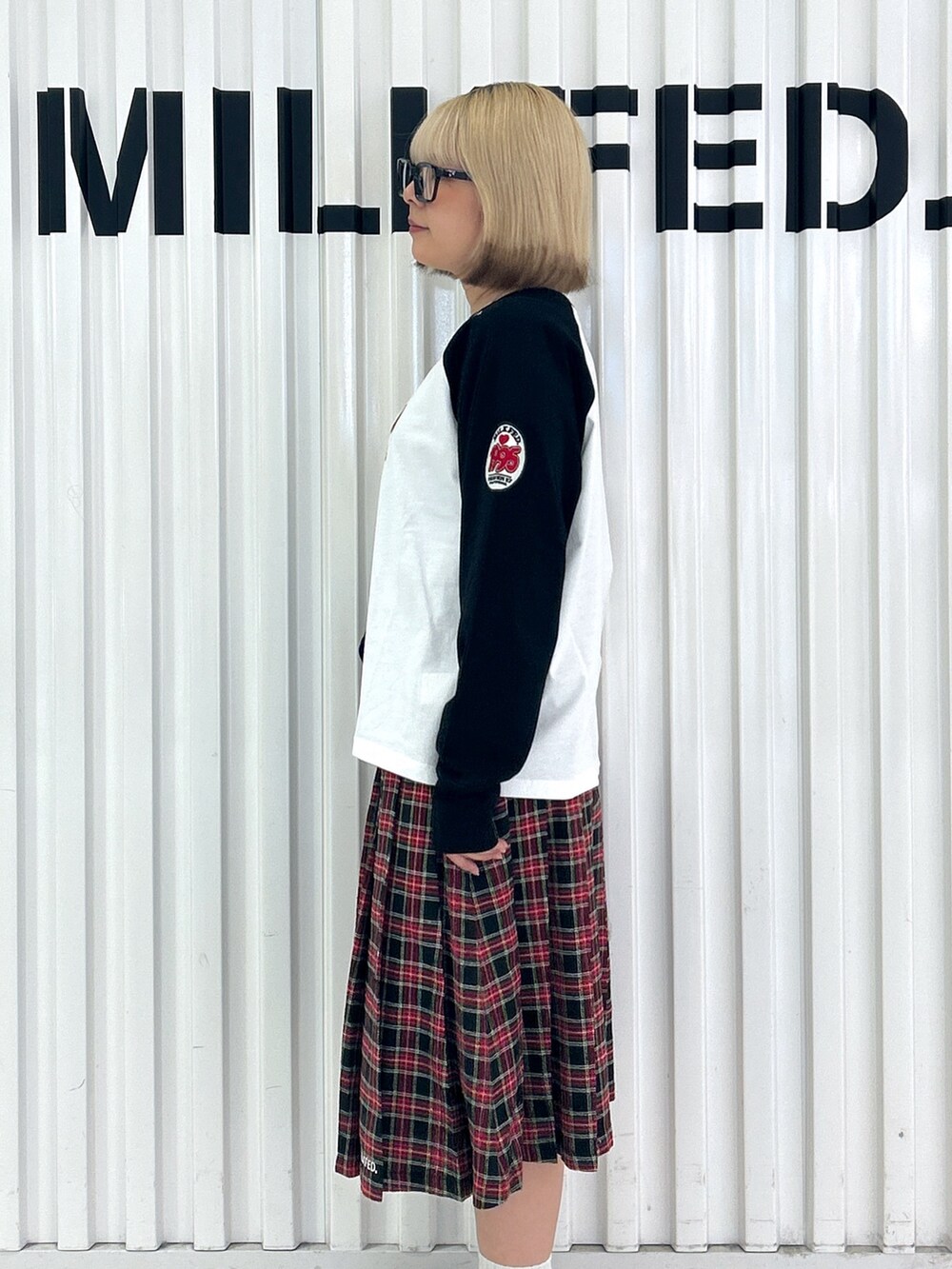 ブラック系のスカート、ホワイト系のTシャツ/カットソー、ブラック系のハンドバッグを着用したレディースの夏コーディネートの7枚目の写真