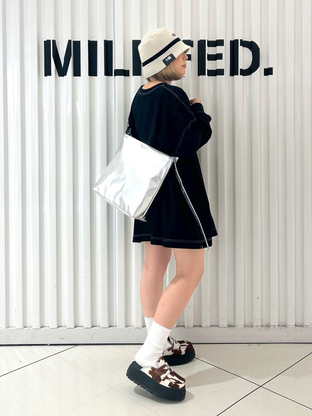 ブラック系のTシャツ/カットソー、シルバー系のショルダーバッグ、ホワイト系のハットを着用したレディースの秋コーディネートの2枚目の写真