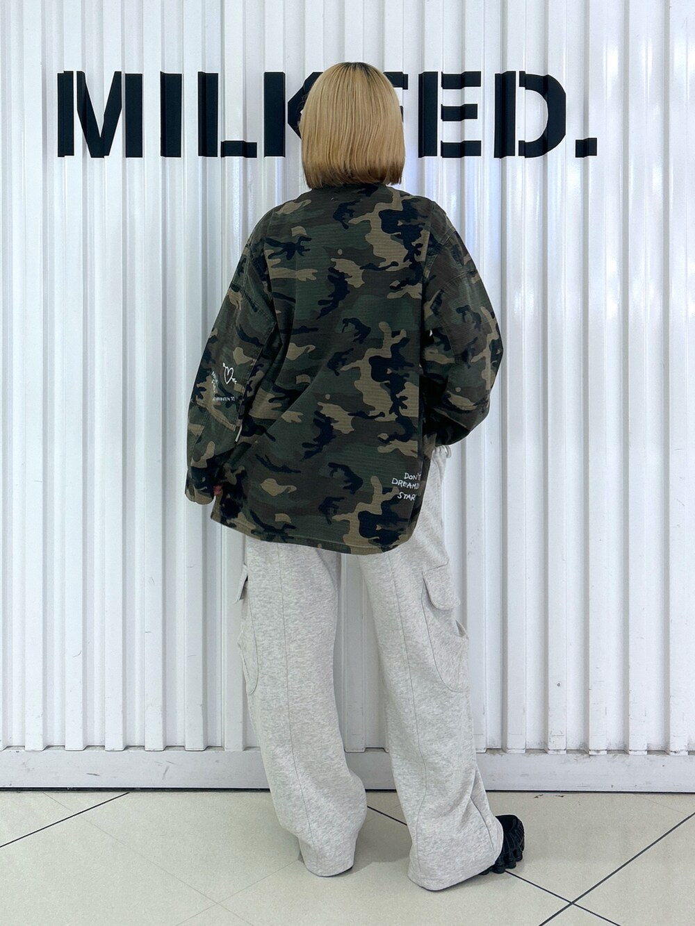 ベージュ系のスウェットパンツ、グリーン系のミリタリージャケットを着用したレディースの秋コーディネートの2枚目の写真