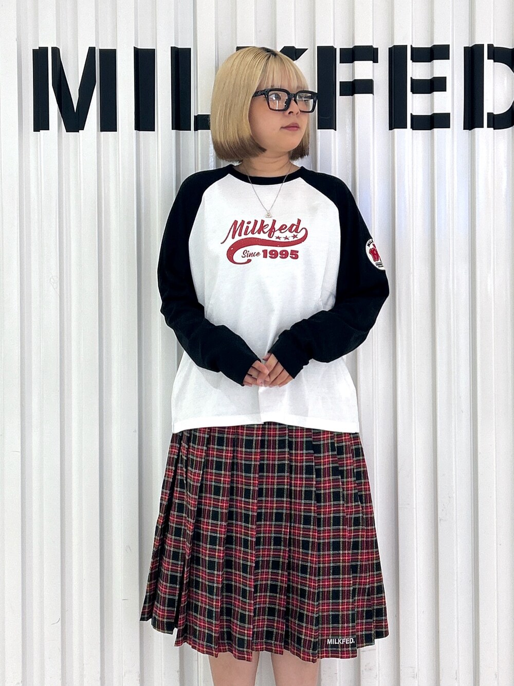 ブラック系のスカート、ホワイト系のTシャツ/カットソー、ブラック系のハンドバッグを着用したレディースの夏コーディネートの6枚目の写真