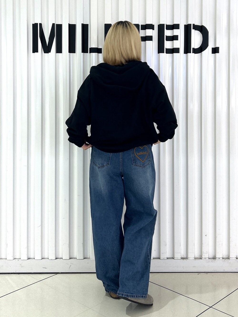 ブラック系のパーカー、ブルー系のデニムパンツ、ブラック系のTシャツ/カットソーを着用したレディースの秋コーディネートの2枚目の写真