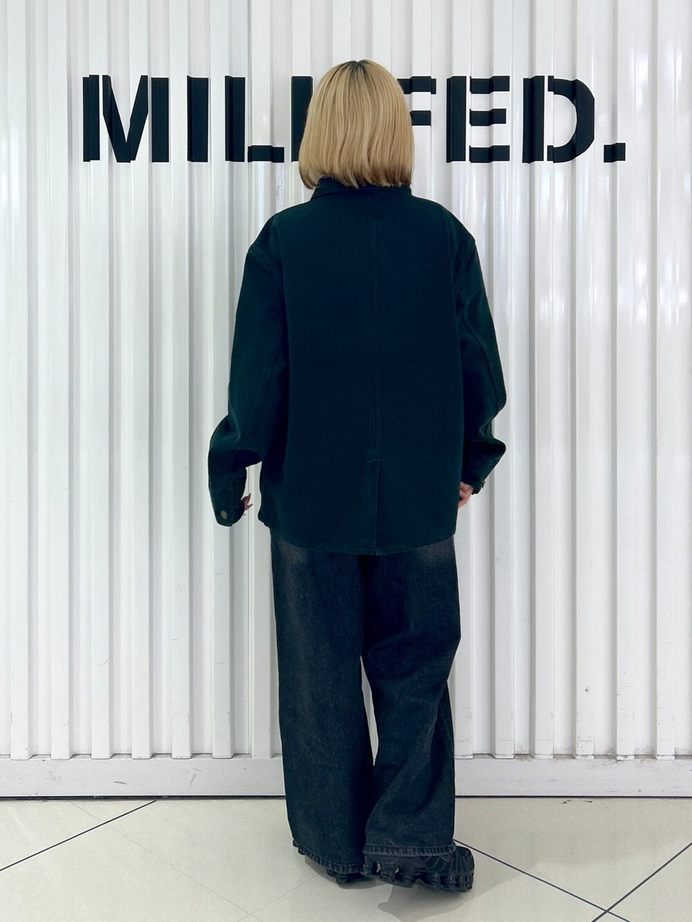 ブラック系のブルゾン、ブラック系のデニムパンツを着用したレディースの秋コーディネートの2枚目の写真