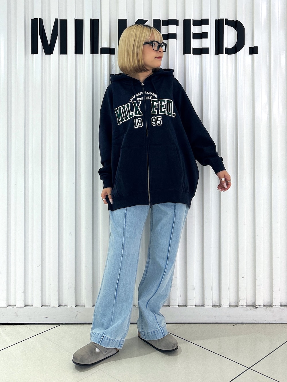 ブルー系のパーカー、ブルー系のデニムパンツ、ブラック系のお弁当箱を着用したレディースの秋コーディネートの3枚目の写真