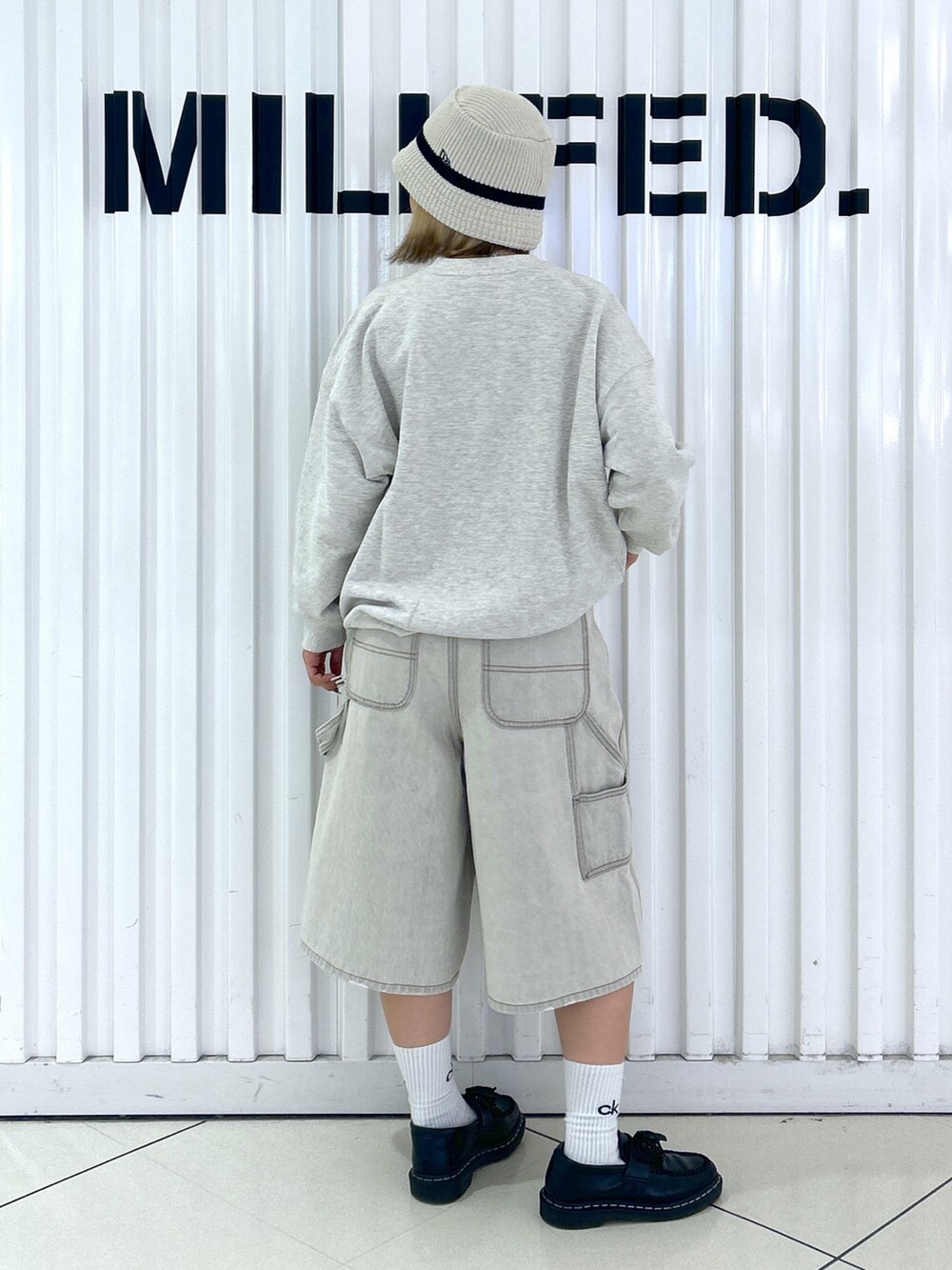 ホワイト系のデニムパンツ、ベージュ系のスウェット、グリーン系のバックパック/リュックを着用したレディースの秋コーディネートの4枚目の写真