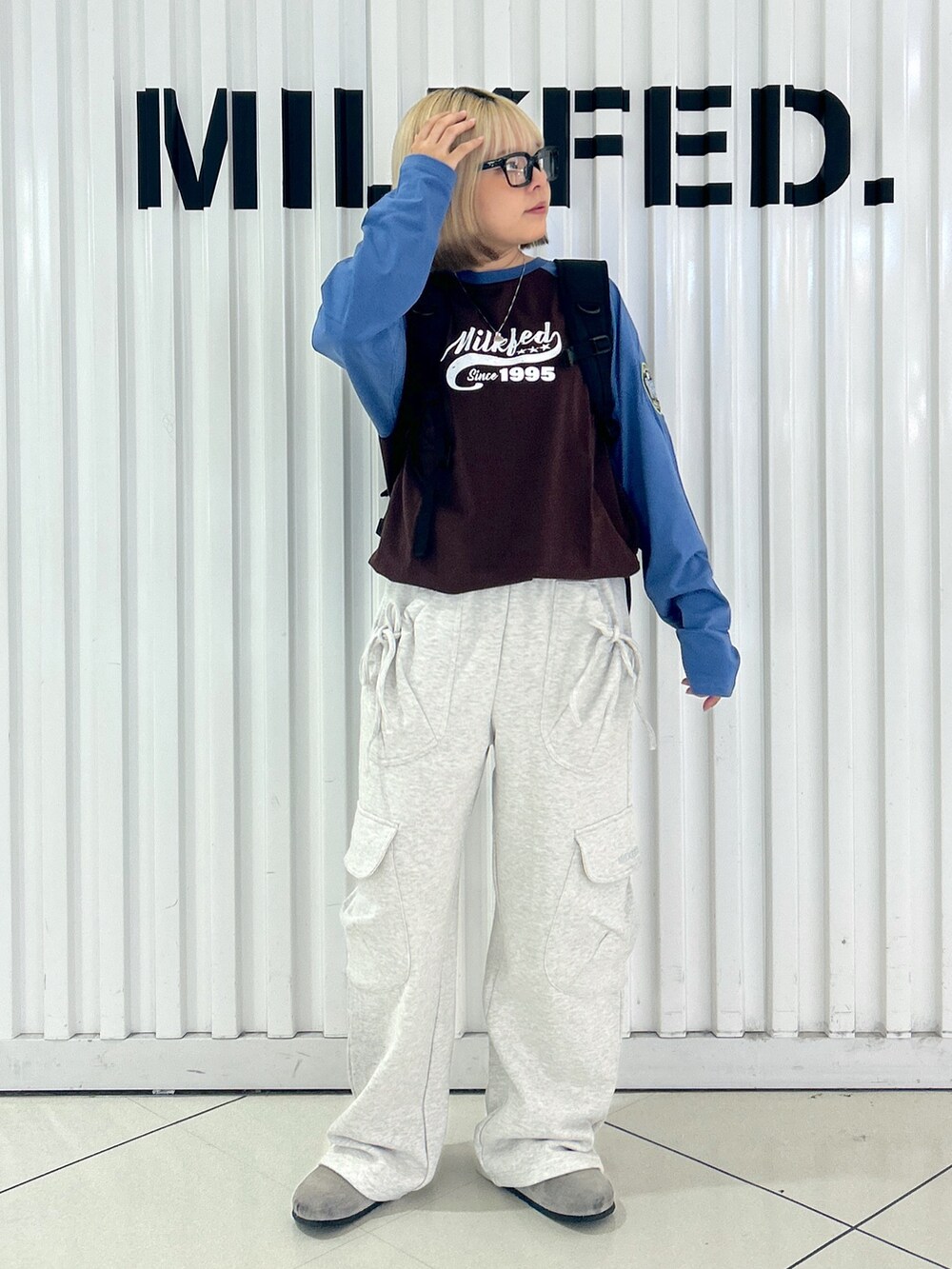 ベージュ系のスウェットパンツ、ブラウン系のTシャツ/カットソー、ブラック系のバックパック/リュックを着用したレディースの夏コーディネートの3枚目の写真